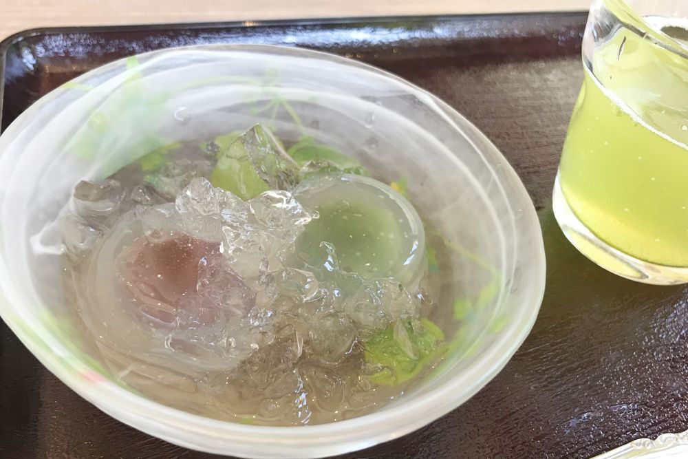 透明な器に盛り付けられた、涼やかな見た目の水まんじゅう。氷の入った水に浸り、冷たい緑茶が添えられた、大垣の豊かな水を感じさせる和スイーツの風景。