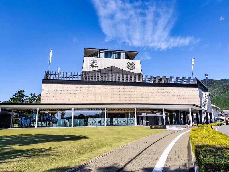 芝生の広場の先に立つ、モダンな外観の岐阜関ケ原古戦場記念館。建物上部には徳川家の「三葉葵」と石田三成の「大一大万大吉」の家紋が掲げられている。