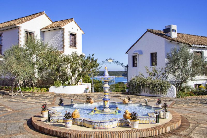 志摩地中海村にあるタイル装飾の噴水と青空に映える白い壁の建物が並ぶ街並み